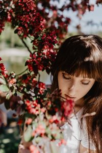 Woman looking down while standing by flowers in park