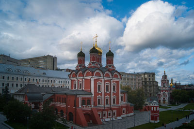 Buildings in city against cloudy sky