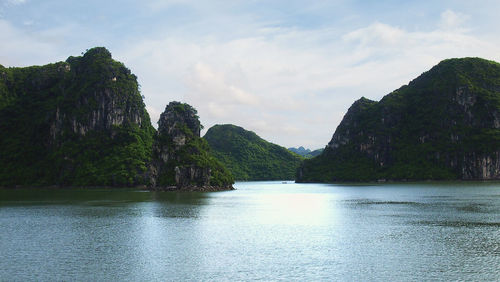 Scenic view of sea and mountains against sky