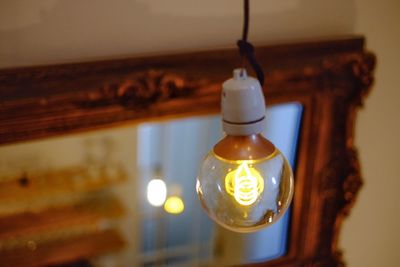 Close-up of illuminated light bulb at home