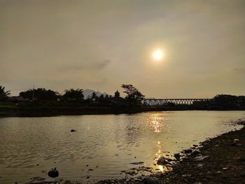Scenic view of lake against sky at sunset