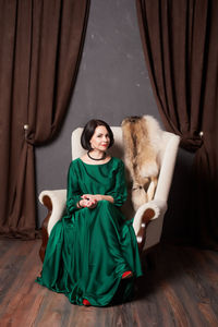 Portrait of woman sitting on armchair at home