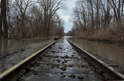 Surface level of flooded railroad track against sky