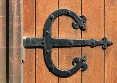 Close-up of old hinge on wooden door