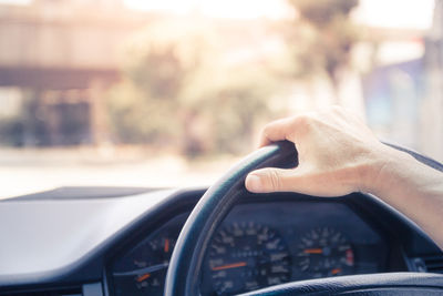 Midsection of person seen through car windshield