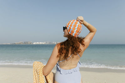 Woman wearing swimsuit enjoying sunny day at beach