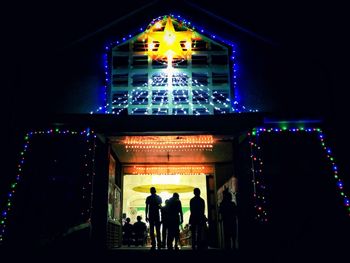 People in illuminated building at night