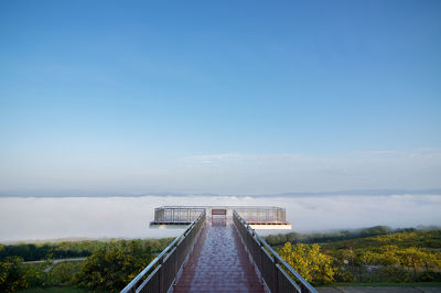 Scenic view of bridge against sky and sea of fog