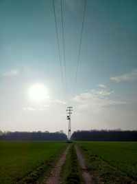 Street amidst field against sky