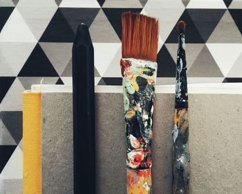 Close-up of painting equipment against patterned wall