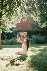 Mother and son sitting by tree at park