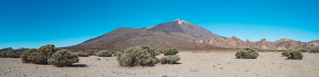 Panoramic view of desert against blue sky