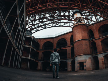 Rear view of man standing against building