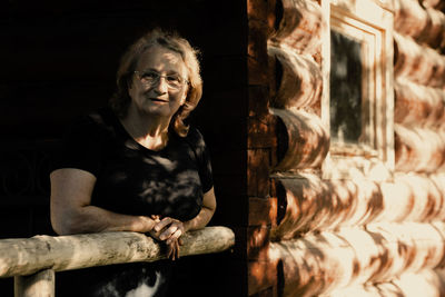 Portrait of elderly woman in glasses close-up on natural background. sunset light on face of senior