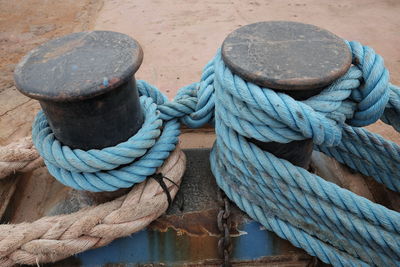 High angle view of ropes tied to bollards