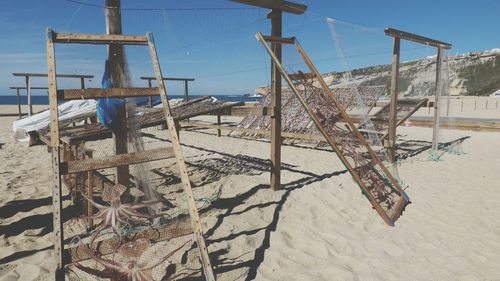 Fishing nets on beach against sky