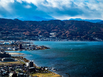 High angle view of sea and cityscape against sky