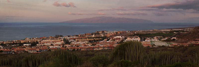 High angle view of townscape by sea against sky