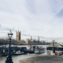 Thames river and palace of westminster against cloudy sky