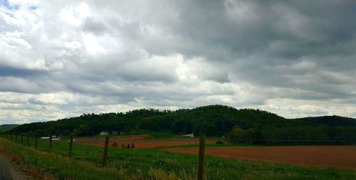 Scenic view of field against storm clouds