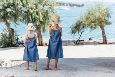 Full length of siblings standing on beach