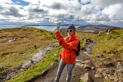Woman taking selfie while standing on mountain