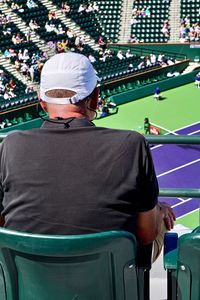 Rear view of man looking at tennis match