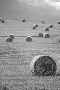 Hay bales on field against sky
