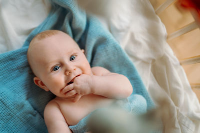 Close-up of cute baby boy on bed at home