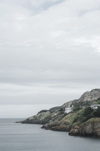 Scenic view of sea and cliff against sky