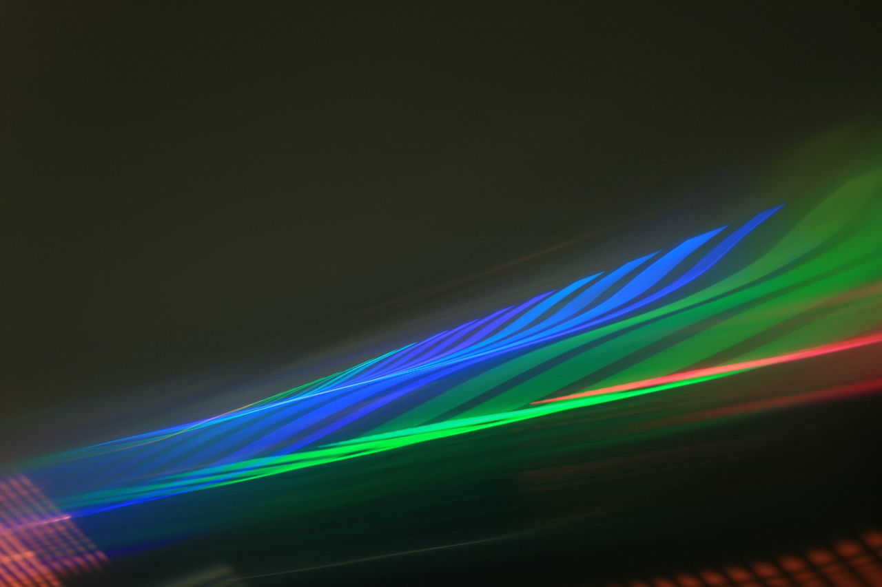 LOW ANGLE VIEW OF ILLUMINATED LIGHT TRAILS AT NIGHT
