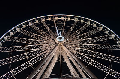 Low angle view of illuminated ferris wheel against sky at night