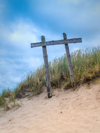 Cross on field against sky