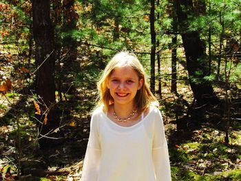 Portrait of smiling young woman in forest