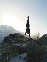 Full length of man standing on rock against sky