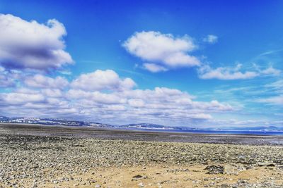 Scenic view of beach against blue sky