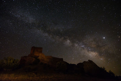 Low angle view of rock formation against sky at night