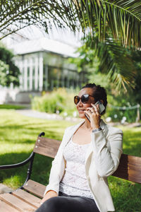 Young asian business woman in casual blazer making phone call outdoor