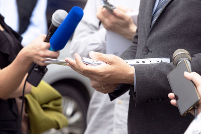 Midsection of man using mobile phone