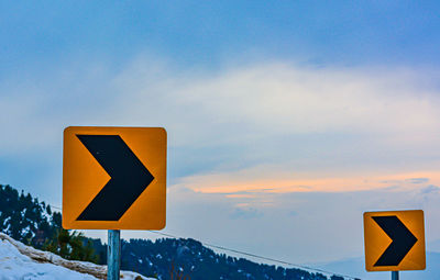 Low angle view of road sign against sky