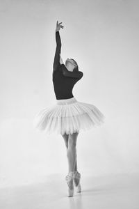 Rear view of woman with arms raised against white background