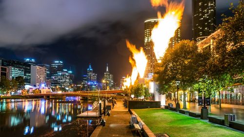 Illuminated cityscape against sky at night