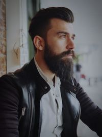 Bearded young man looking away