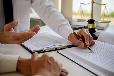 Midsection of lawyer working at desk in office