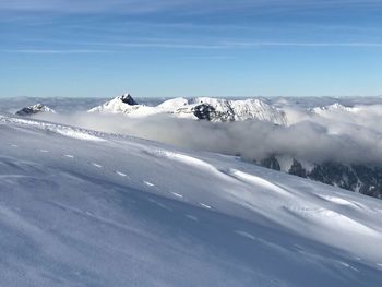 Scenic view of snow mountains against blue sky