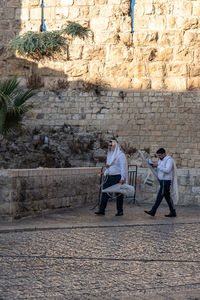 People walking on stone wall