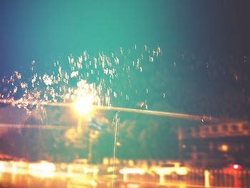 Close-up of illuminated lights against sky at night