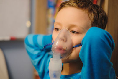 Close-up of boy wearing oxygen mask in hospital