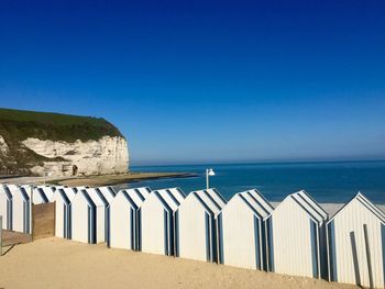 Scenic view of beach huts against blue sky 