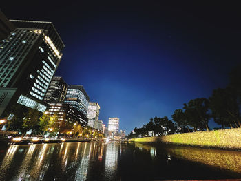 Low angle view of illuminated buildings against sky at night